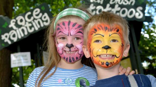 Two children with their faces painted at the zoo