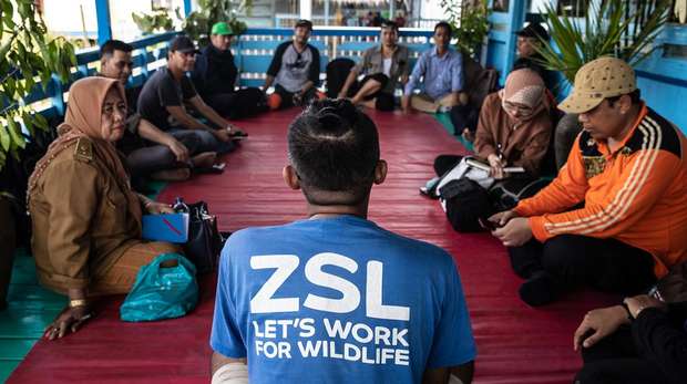 Photo- A group of Indonesian locals and a ZSL representative, sat in a circle having a discussion.
