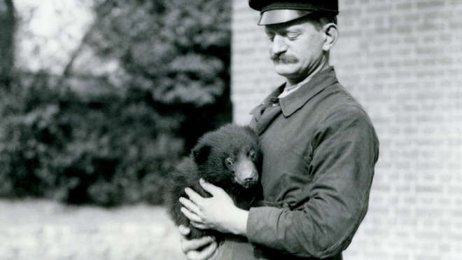 1921 - A Keeper holds a Sloth Bear cub at London Zoo (c) ZSL