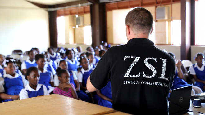 ZSL Conservation volunteer giving a presentation about the mountain chicken frog to school children in Dominica