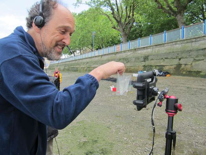 Joe Pecorelli shows students a juvenile fish that has been found as part of ZSL’s survey work, holding it up to the camera (in a transparent container) so they can see it.