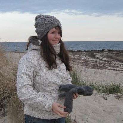 Photo - Conservationist Kate Moses standing on a beach wrapped up in a thick coat and woolly hat.