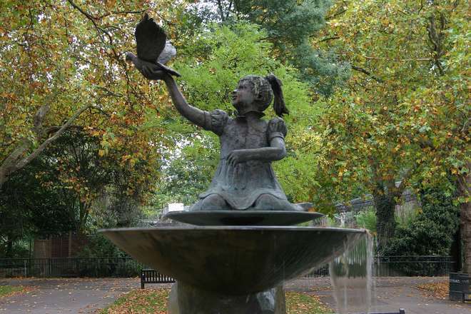 Bronze sculpture of a girl releasing a dove