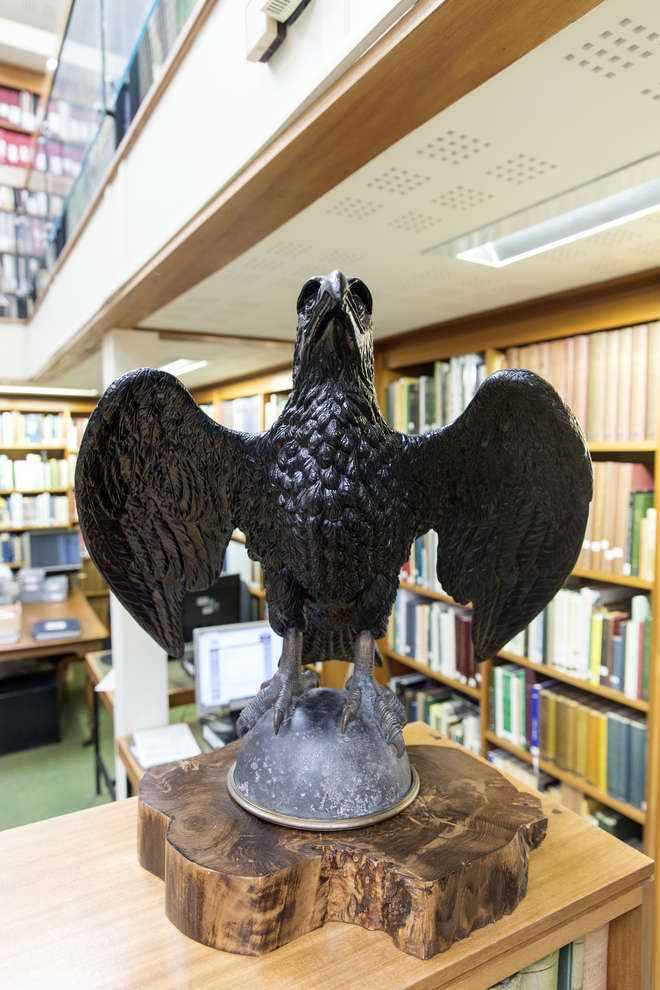 Iron sculpture of an eagle, perched with wings outstretched 