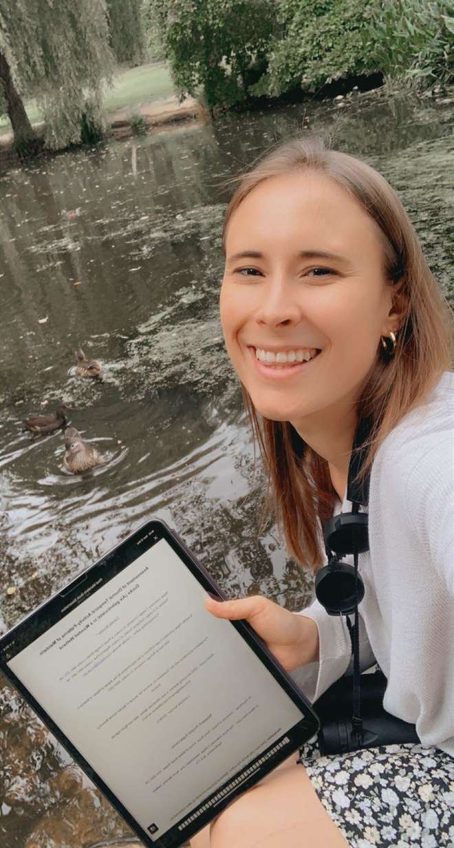 Biologist Camille Munday sits by the lake with her iPad at the ready to record her observations