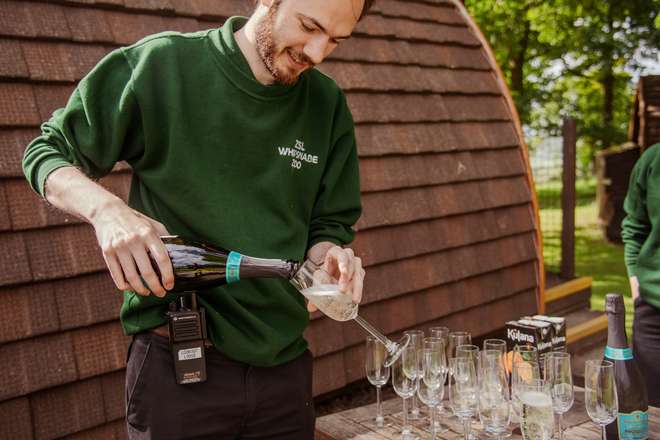 A member of staff pouring prosecco