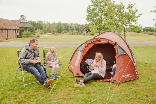 A picture of a family sat outside their tent